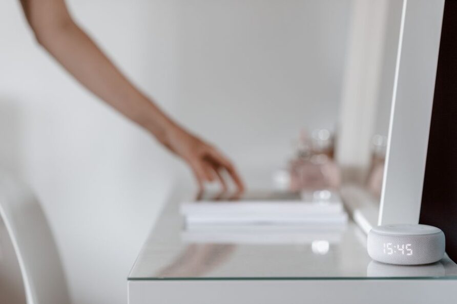 Een moderne woonkamer met slimme apparaten zoals een robotstofzuiger, slimme verlichting en een tablet, die het dagelijks leven vergemakkelijken.